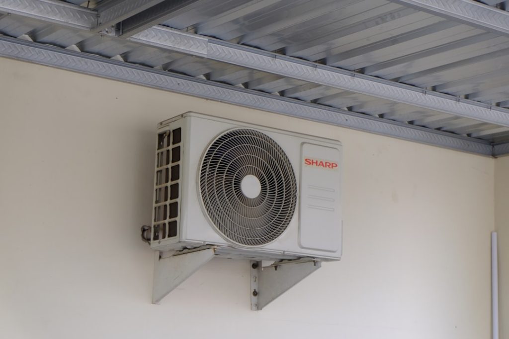 Outdoor air conditioning unit mounted on a wall, part of a home cooling and ventilation system commonly used in residential and commercial buildings.