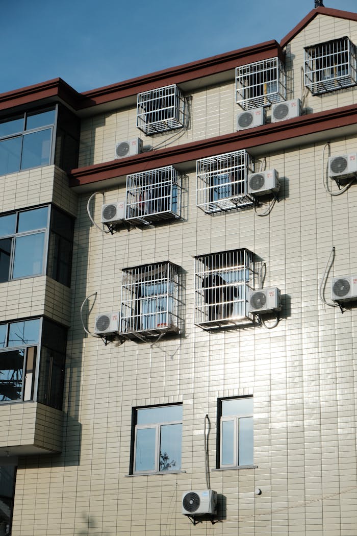 Mastering the First Impression: Your intriguing post title goes here Exterior of a building with multiple air conditioners and window cages.